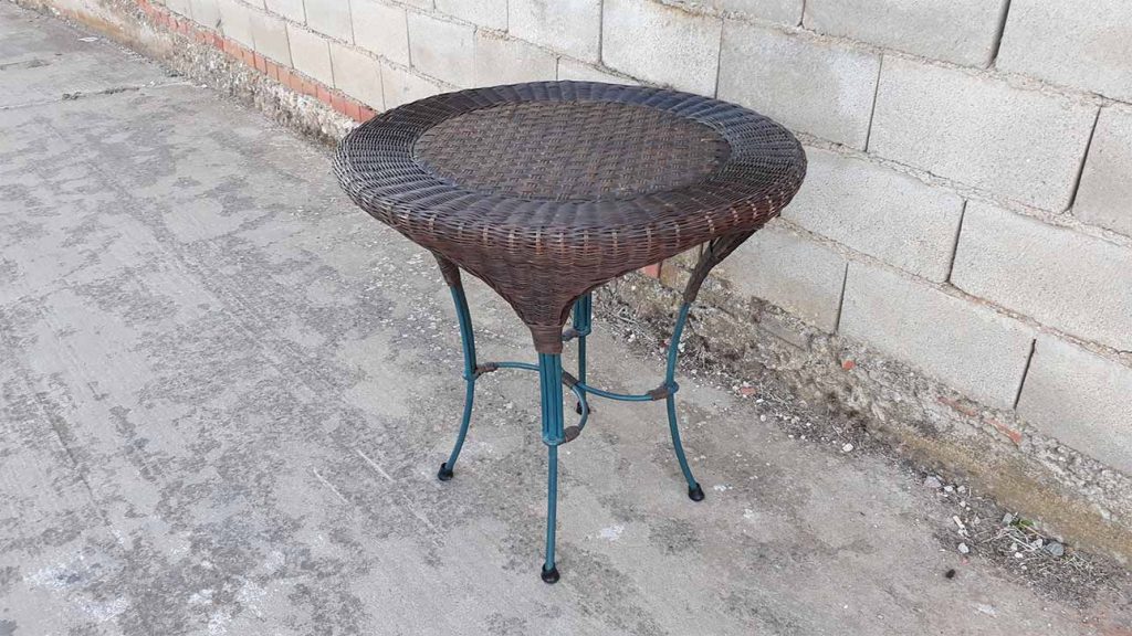 Mesa de mimbre y metal antigua terraza o jardín. Mesa auxiliar salón