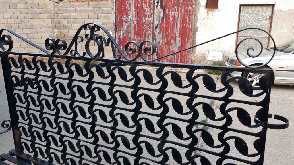 Banco antiguo de hierro forjado. Banco separador celosía antigua de